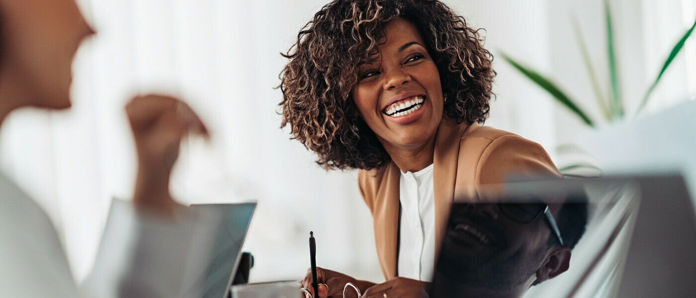 A woman smiles at her colleagues in a meeting